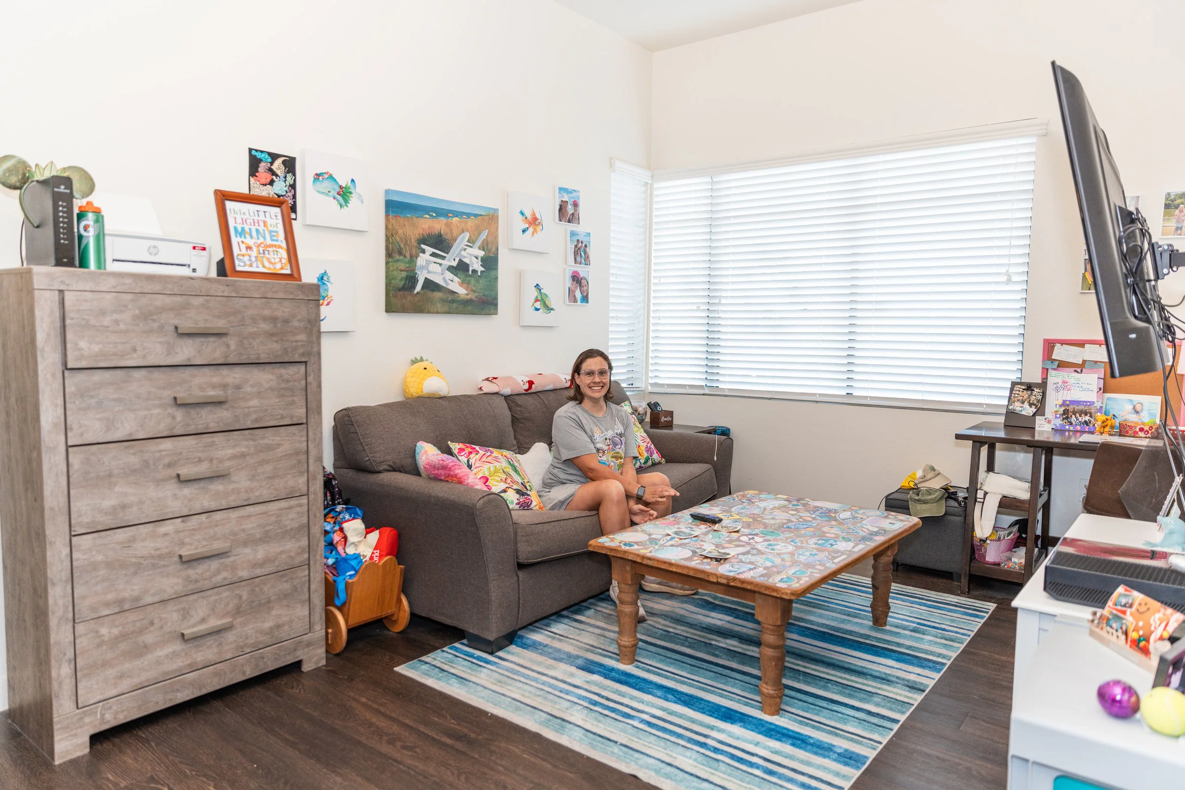 A resident relaxing on the couch in her own Treasure House apartment